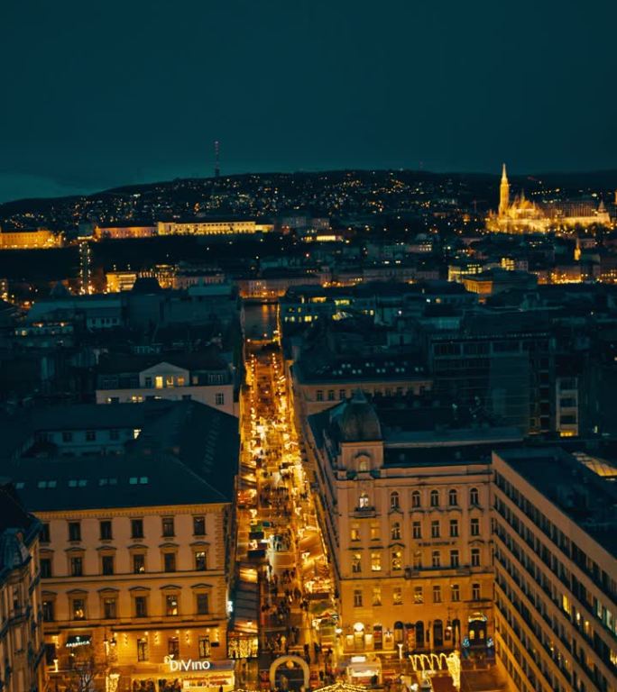 匈牙利布达佩斯，夜晚被城市景观包围的圣诞市场灯火通明