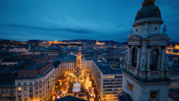 圣斯蒂芬大教堂的钟楼俯瞰布达佩斯的城市景观和圣诞市场黄昏，匈牙利