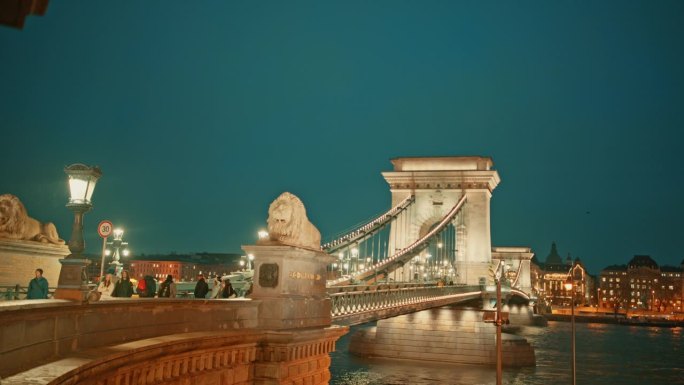 在匈牙利布达佩斯，黄昏时分，人们在多瑙河上的sz<s:1> chenyi链桥上手持拍摄，天空湛蓝