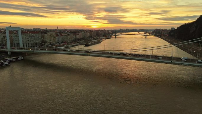 无人机拍摄的车辆行驶在伊丽莎白桥上的道贝河在布达佩斯城市景观日落期间在匈牙利