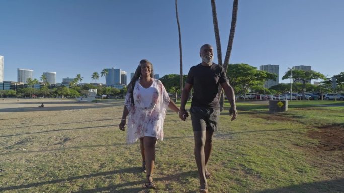 一对非裔美国老年夫妇穿过夏威夷檀香山的海滩公园