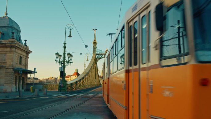手持拍摄的有轨电车在自由桥上对蓝天在布达佩斯，匈牙利