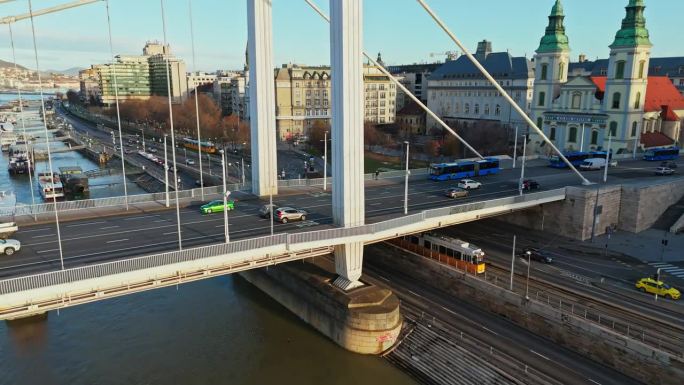 高角度无人机拍摄的车辆行驶在伊丽莎白桥由教区教堂对蓝天在布达佩斯，匈牙利
