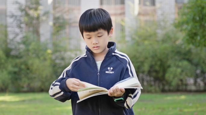 小男孩校园走路看书阅读