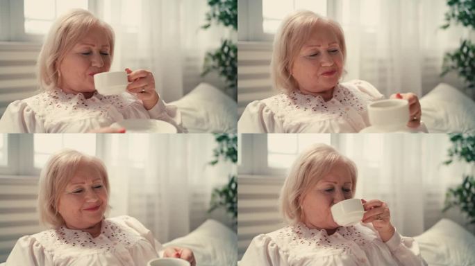 愉快的老年妇女在床上喝咖啡，早上的仪式，退休生活
