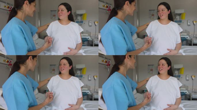 女产科医生握着孕妇的手，一边愉快地和她交谈，一边准备分娩
