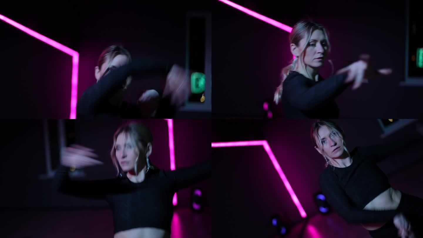 住相机。在霓虹灯的大厅里跳舞的女人。在表演Waacking时积极挥舞手臂和手势的特写。