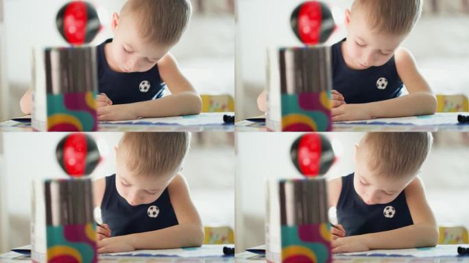 绘画。小男孩在家里用铅笔涂色。孩子在桌上画画。儿童人格心理学。帮助获得自信。创意与教育理念。