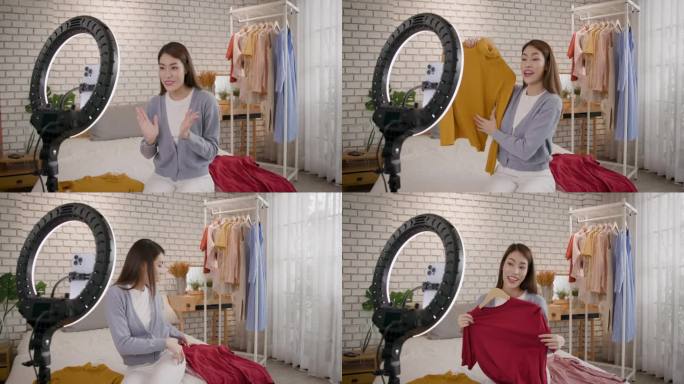 年轻的亚洲女性在家里用手机在社交网络上直播自己卧室里的教程视频，并在网上出售一件衣服