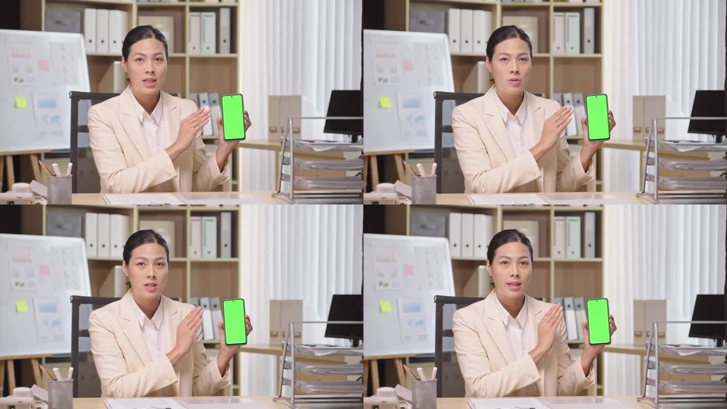 女企业家向镜头展示带有绿色色度键屏的智能手机