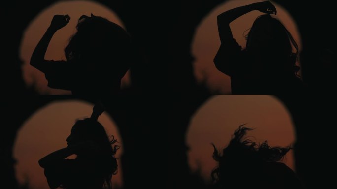 慢镜头，年轻美丽的女人在夕阳下独自在公园里跳舞