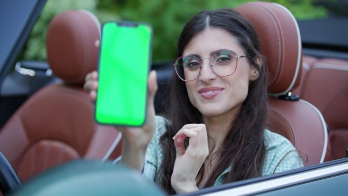 司机展示彩色键手机坐在敞篷车。一名女子手持绿屏智能手机对着镜头。