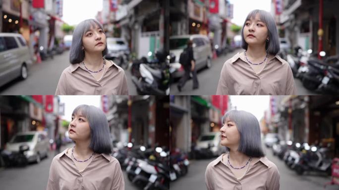 慢动作视频，一个年轻的台湾女人与白发漫步在迪化街的老街。