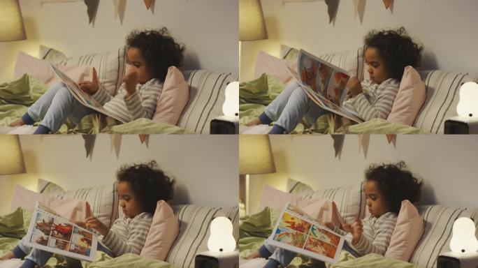 非裔美国小男孩在看关于恐龙的漫画书