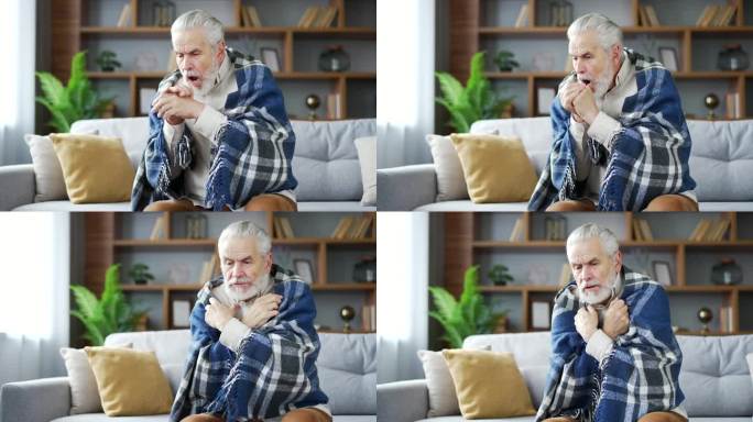 一位白发苍苍的老人裹着毯子坐在家里客厅的沙发上冻住了。心烦意乱的成熟退休男冷室内。
