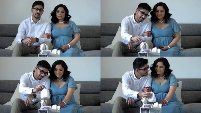 一对年轻的印度夫妇坐在沙发上翻看一个装满婴儿用品和超声波照片的盒子。