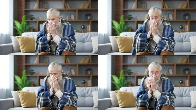 生病的老人裹着毯子坐在家里客厅的沙发上流鼻涕。