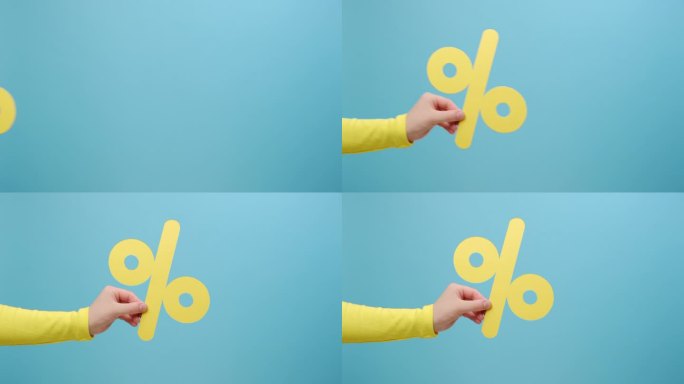 特写侧视图的女人手拿纸黄色的百分之一标记，呈现大折扣，摆出孤立的纯蓝色背景墙的工作室与复制空间的广告
