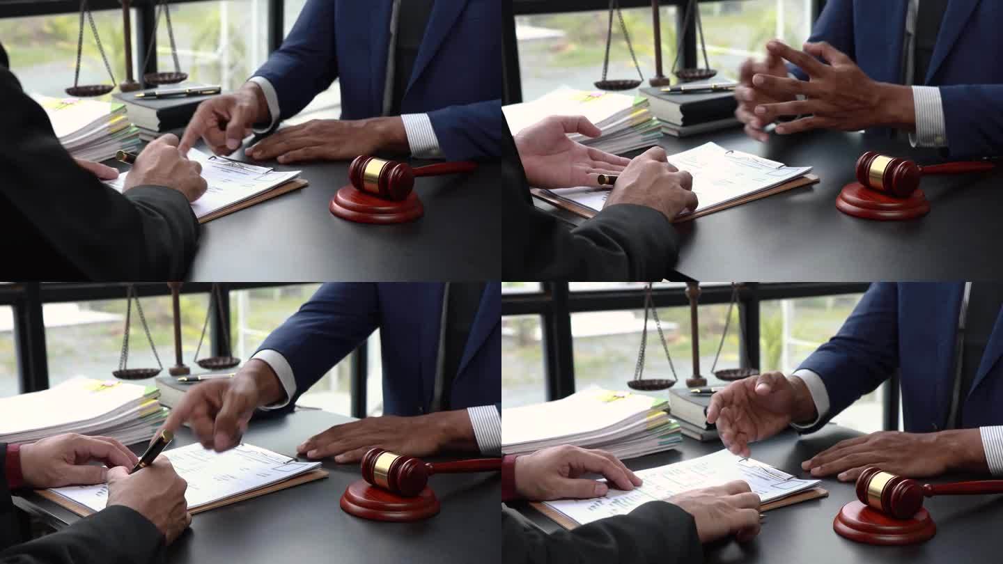正义与法律握手言和的概念。法律顾问在律师事务所后台用木槌和法律或法律会议向客户出示签订的合同