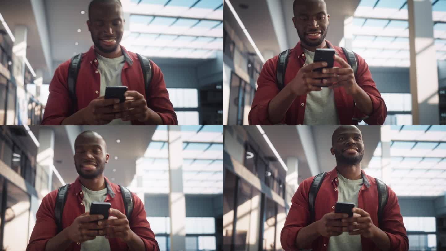 一个年轻的黑人男子走过公司办公大厅，用智能手机浏览网页，面带微笑。成功的企业家走路和思考创业策略。低
