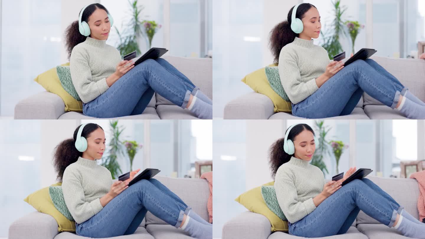 女人把耳机和信用卡放在平板电脑和沙发上，用于音乐流媒体订阅、电子商务或网上购物。年轻的非洲人对数字技