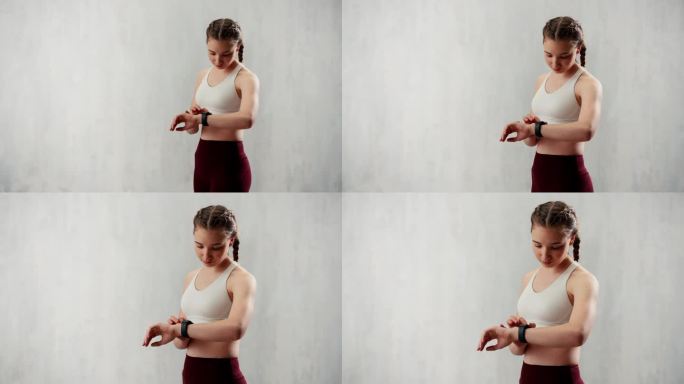 年轻女子设置和看运动智能手表。健身女检查她的表现。