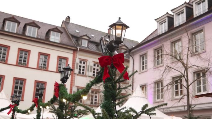 欧洲小镇集市广场灯柱上的圣诞红蝴蝶结和绿色金箔