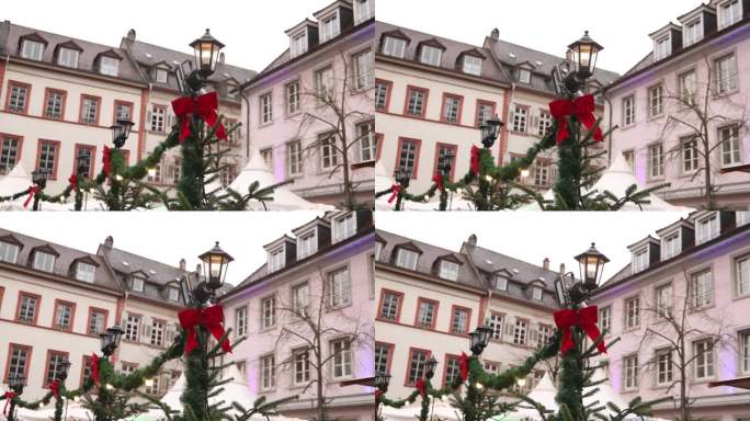 欧洲小镇集市广场灯柱上的圣诞红蝴蝶结和绿色金箔