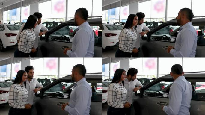 一对拉丁美洲夫妇在经销商那里听推销员谈论汽车的特点，看起来很兴奋