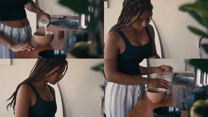 年轻的黑人女士在早上把牛奶倒进健康的麦片碗里