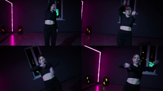 住相机。在霓虹灯下的舞蹈大厅里跳舞的女人。在表演舞蹈时积极地挥动手臂和手势。