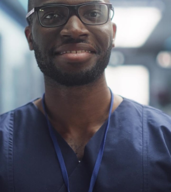 垂直屏幕:一个黑人医疗保健专业人员的肖像，对着相机摆姿势，微笑着看着相机。戴眼镜在医院办公室工作的临