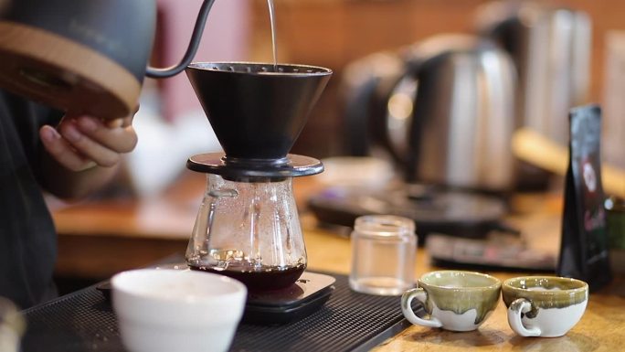 咖啡师通过将溢出的热水倒在咖啡粉上来制作滴漏咖啡