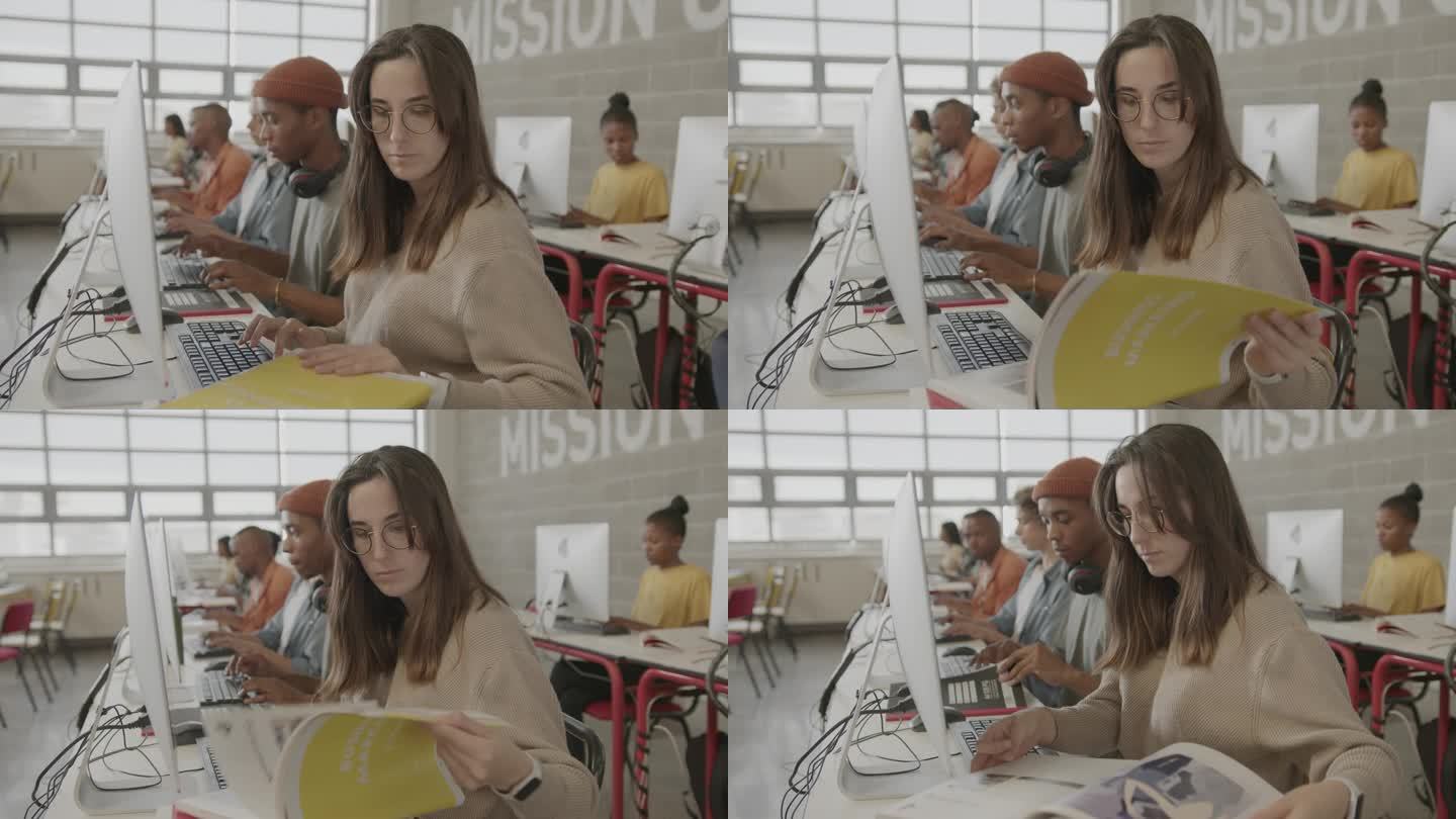 女大学生在学校的计算机课上读课本