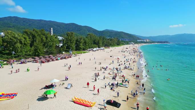 海南三亚亚龙湾航拍蓝天白云海岸线上的游客