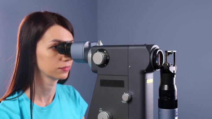 眼科医生使用现代设备检查一个人的眼睛，并为病人做激光视力矫正准备。眼科诊所的现代诊断设备。