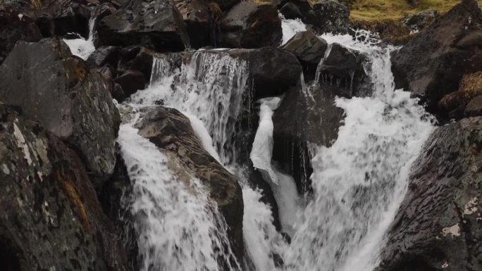 强大的水流穿过深色火山岩，冰岛河流