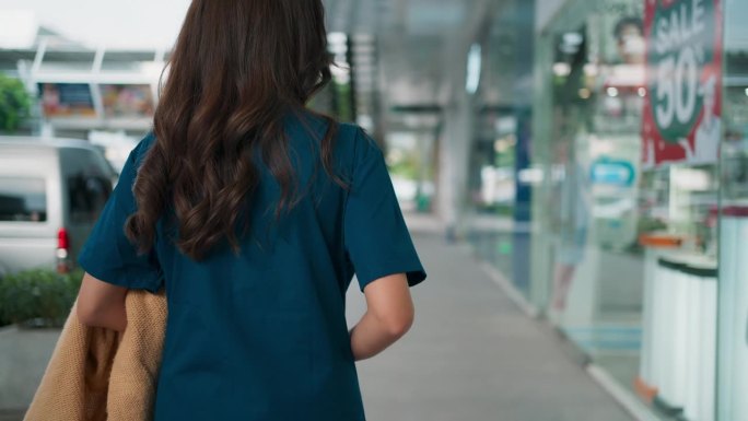 积极的年轻亚洲医护人员医生或护士穿着工作服在走廊站立和行走，医疗技术人员在日常生活中活动