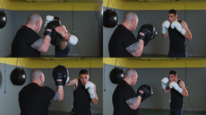 一个年轻强壮的自由搏击运动员在拳击馆里和他的自由搏击教练对练