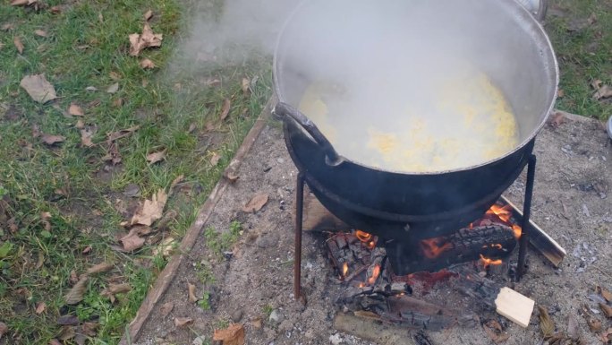 在明火上的大锅中准备玉米粥
