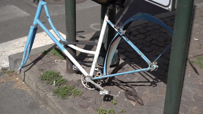 没有轮子的自行车。被拆解的自行车停在路上。