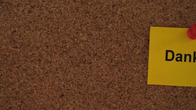 一张写着“丹克”的黄色纸条!(用德语说谢谢)把它钉在一块软木板上。