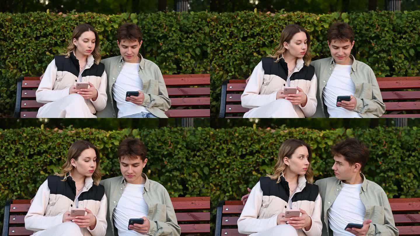 一个嫉妒的女人在公园的长椅上休息时偷看男友的手机