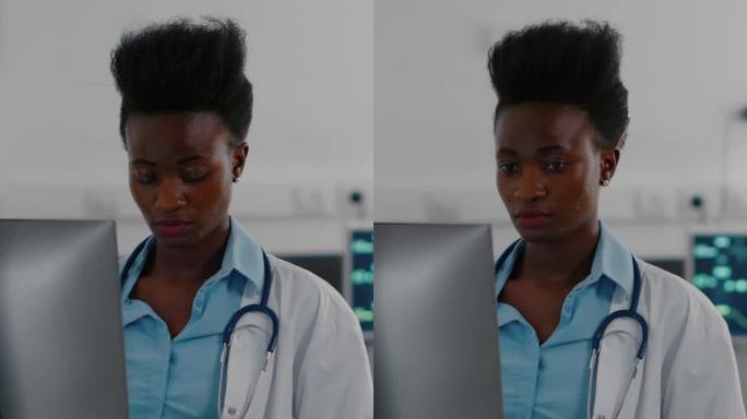 垂直视频:非裔美国医生在电脑上输入医学专业知识的正面视图