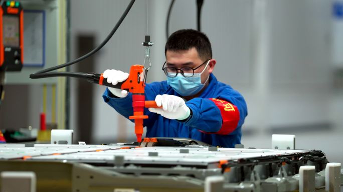 汽车工厂生产组装电池组工人拧螺丝