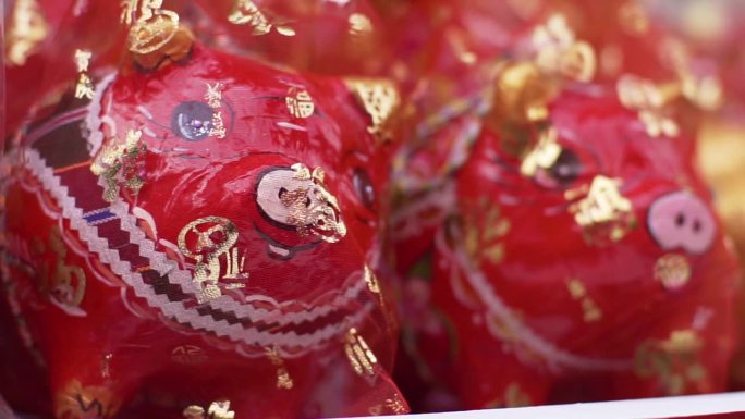 红色的小猪储蓄罐上盖着红纱，在各种仪式上作为吉祥的礼物