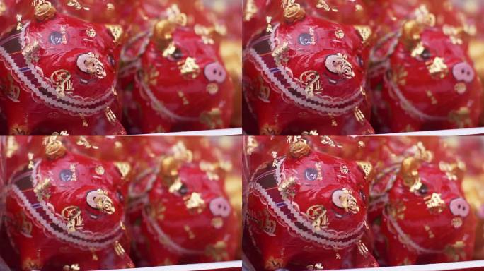 红色的小猪储蓄罐上盖着红纱，在各种仪式上作为吉祥的礼物