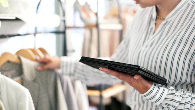 妇女，平板电脑和手的服装货架检查，库存或时尚的小型企业在精品店。具有物流、设计或创业技术的创意女性特