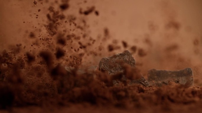 超级慢动作的飞行组生巧克力块成粉。