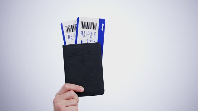 手，护照和机票的旅行特写在机场的灰色背景在摄影棚旅行。登机牌，入境证件和准备离境的旅客